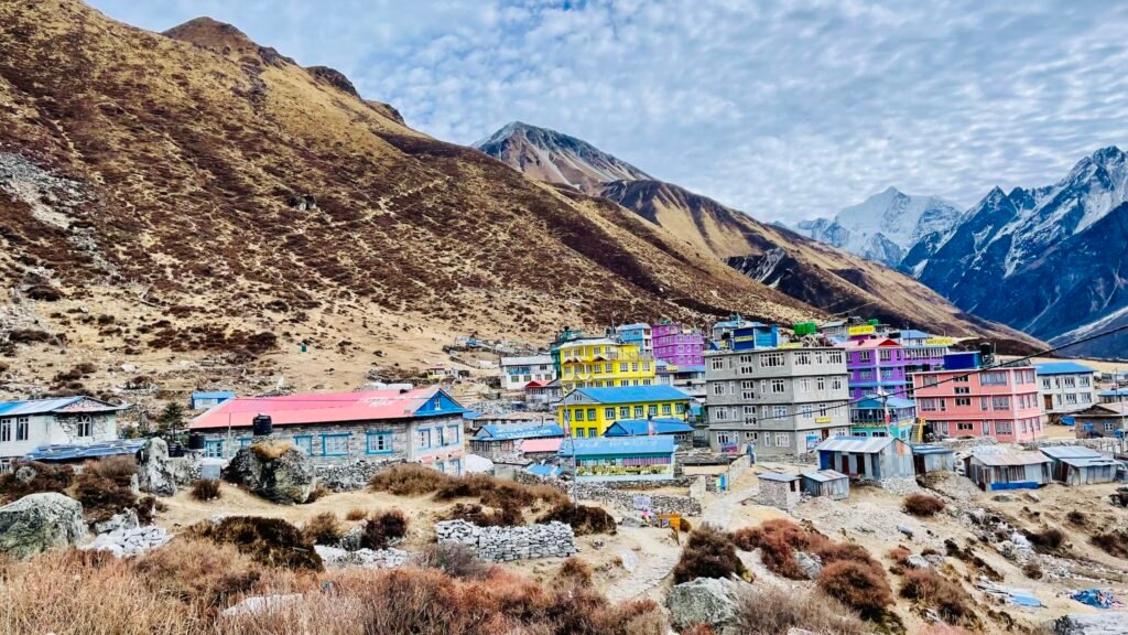 A picturesque view of Kyanjin Village nestled in the Langtang Valley, surrounded by snow-capped Himalayan mountains.