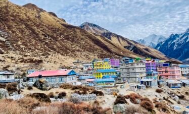 A picturesque view of Kyanjin Village nestled in the Langtang Valley, surrounded by snow-capped Himalayan mountains.