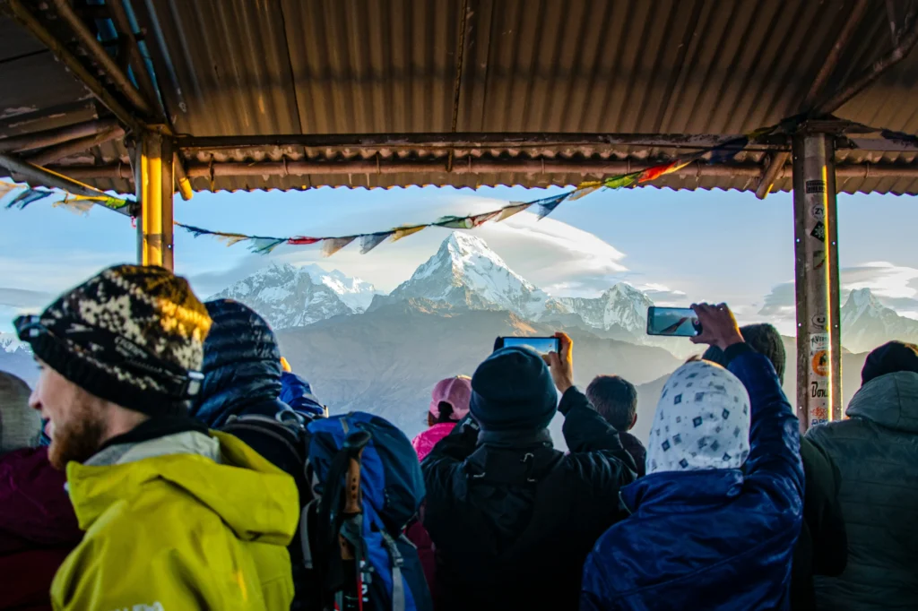Trekkers taking pictures of the stunning mountain view from Poon Hill, Nepal