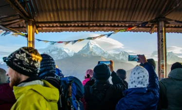 Trekkers taking pictures of the stunning mountain view from Poon Hill, Nepal