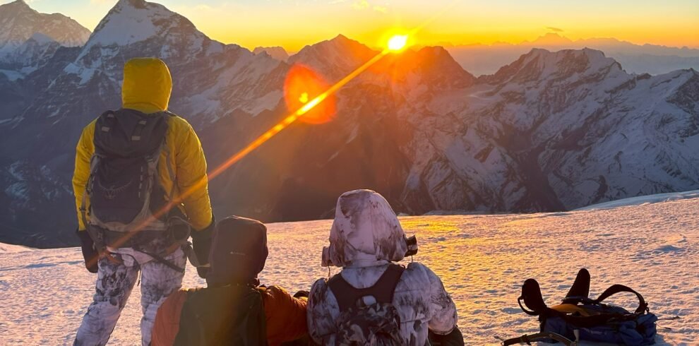 Climbers enjoying the sunrise view from the snowy summit of Mera Peak.