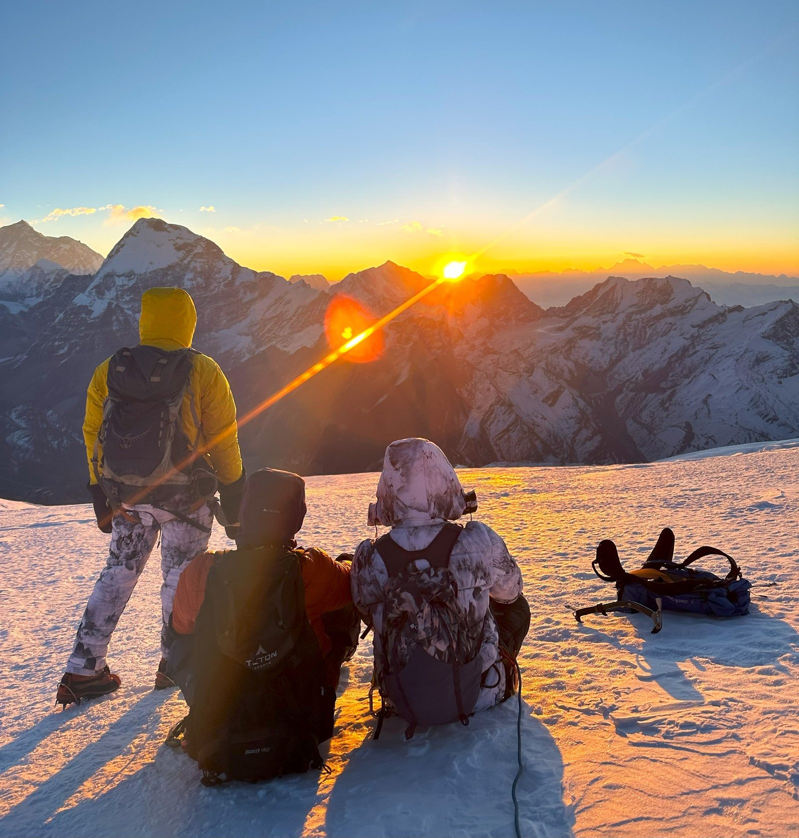 Climbers enjoying the sunrise view from the snowy summit of Mera Peak.