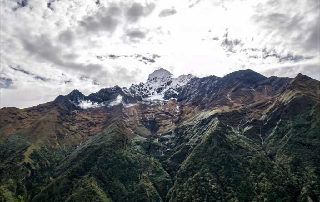 Everest Scenic Flight view of a snow-capped Himalayan peak rising above a green valley